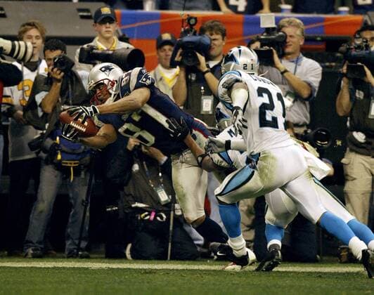 Wide Receiver David Givens (li., New England Patriots) sichert die Pille vor seinen Gegenspielern der Carolina Panthers - PUBLICATION FOR GERMAN, SWISS, AUSTRIAN AND HUNGARIAN MEDIA ONLY (Icon8037194) American Football Herren NFL 2003 2004, Superbowl, Super Bowl, New England Patriots - Carolina Panthers 32:29, Finale Gruppe Houston Dynamik, EDITORIAL USE ONLY