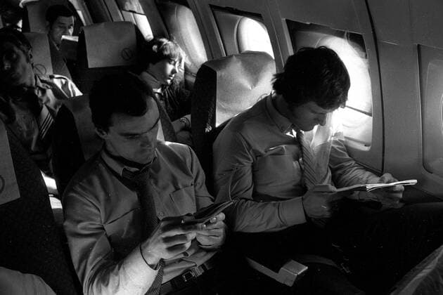 Ulrich Wehling (re.) und Henry Glaß (beide DDR) vertreiben sich die Flugzeit auf dem Weg nach Lake Placid beim Lesen Nordische Kombination OS Winter Herren Olympische Winterspiele 1980, Olympia, Olympiade, Spiele, Ski Nordisch, Vneg, Vsw Gruppe Lake Placid