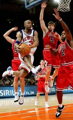 Stephon Marbury (New York Knicks) schreitet durch die Lüfte - bestaunt von Eddy Curry (re.) und Andres Nocioni (beide Chicago Bulls) - PUBLICATION ONLY FOR GERMAN, SWISS, AUSTRIAN AND HUNGARIAN MEDIA (Icon7895167) Basketball Herren NBA 2004 2005, New York Knicks - Chicago Bulls 86:88, NY, N Y Gruppe New York Dynamik, Höhe, EDITORIAL USE ONLY