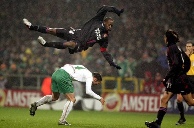 Sidney Govou (Lyon) mit einer Flugeinlage über Fabian Ernst (Bremen) hinweg Fußball EC 1 Herren Champions League 2004 2005, Achtelfinale, SV Werder Bremen - Olympique Lyonnais 0:3, OL Gruppe pan8365 Bremen Dynamik, Höhe  