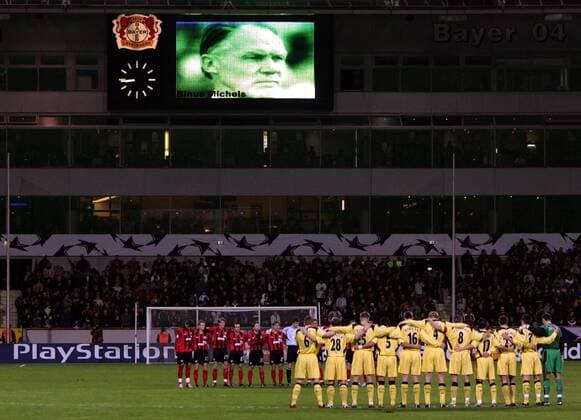 Die Teams aus Liverpool (vorn) und Leverkusen gedenken der verstorbenen holländischen Trainerlegende Rinus Michels, dessen Bild auf der Anzeigetafel des Stadions erscheint Fußball EC 1 Herren Champions League 2004 2005, Bayer 04 Leverkusen - FC Liverpool 1:3, Achtelfinale Totale Leverkusen