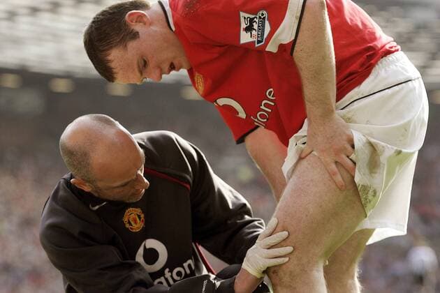 Wayne Rooney (re.) läßt sich von Physiotherapeut Rob Swire (beide Manchester United) am Oberschenkel behandeln - EDITORIAL USE ONLY. No use with unauthorised audio, video, data, fixture lists, club league logos or live services. Online in-match use limited to 120 images, no video emulation. No use in betting, games or single club league player publications. Fußball Herren English Premier League 2004 2005, 1. Englische Liga, Manchester United, ManU Gruppe Manchester