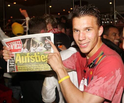 Lukas Podolski (Köln) mit einer Ausgabe des Kölner Express, die den Wiederaufstieg seines Vereins verkündet Fußball 2. BL Herren Saison 2004 2005, 1. FC Köln, Aufstieg, Aufsteiger, Aufstiegsfeier, Feier, feiern, Ankunft Einzelbild Köln