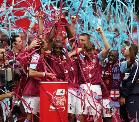 Die Spieler von West Ham feiern ausgelassen den Aufstieg - V li. Anton Ferdinand, Nigel Reo Coker (mit Aufstiegspokal), Christian Dailly (verdeckt), Teddy Sheringham und Shaun Newton -  Fußball Herren Football League Championship 2004 2005, 2. Englische Liga, West Ham United, Aufstiegsfeier, Feier Gruppe Papierschlangen Cardiff Wales Freude, Begeisterung,