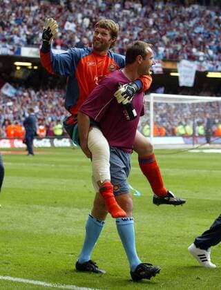 Torwart James Walker (West Ham) zeigt wie man verletzt jubelt - Im Huckepack seines Torwarttrainers -  Fußball Herren Football League Championship 2004 2005, 2. Englische Liga, West Ham United, Aufstiegsfeier, Feier Gruppe Sekt, Champagner, verletzt, Verletzung Cardiff Wales