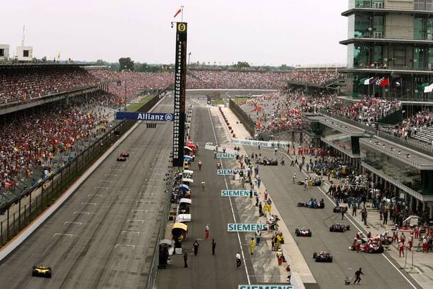Verhärtete Fronten in der Formel 1: Während die Boliden mit Bridgestone Reifen zur Startaufstellung rollen (li.), stellen die Teams mit Michelin Reifen ihre Boliden in der Boxengasse ab Motorsport Grand Prix Herren Großer Preis von der USA 2005, Formel 1 Weltmeisterschaft, F1, F, GP, WM Totale Indianapolis Motor Speedway Indianapolis