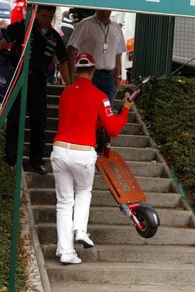 Michael Schumacher (Deutschland Ferrari) trägt seinen Scooter über eine Treppe Motorsport Grand Prix Herren Großer Preis von Frankreich 2005, Formel 1 Weltmeisterschaft, F1, F, GP, WM Einzelbild Magny-Cours