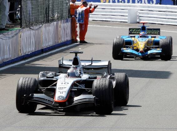 Juan Pablo Montoya (Kolumbien McLaren Mercedes) winkt aus seinem Boliden den Anhängern zu, dahinter Fernando Alonso (Spanien Renault) Motorsport Grand Prix Herren Großer Preis von England 2005, Formel 1 Weltmeisterschaft, F1, F, GP, WM Gruppe Silverstone