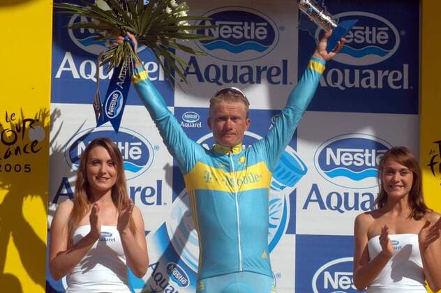 Etappensieger Alexander Vinokourov (Kasachstan T Mobile) während der Siegerehrung nach der 11. Etappe der Tour de France 2005 mit zwei netten Hostessen an seiner Seite -  Radsport Herren Tour de France 2005, ProTour, Straßenradsport, Straße, Rad, Bergetappe, Berg, Berge Gruppe 11. Etappe: Courchevel - Briancon Freude,