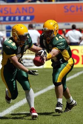 Quarterback David Ward (re.) gibt die Pille an Running Back Andrew Asher (beide Australien) weiter American Football Länderspiel Herren World Games 2005, Worldgames, Nationalmannschaft, Nationalteam, Nationaltrikot, Länderspiel Gruppe Duisburg Dynamik,