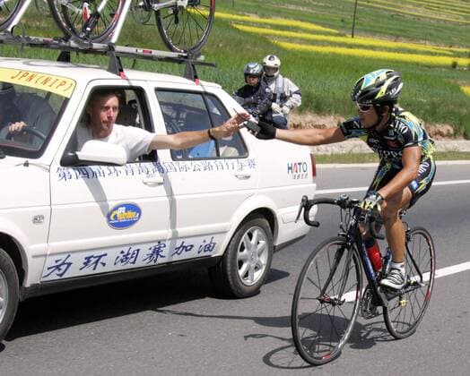 Kazuya Okazaky (Japan Team Nippo) tauscht während der Fahrt sein Funkgerät aus -  Radsport Herren Tour of Qinghai Lake 2005, Straßenradsport, Straße, Rad Gruppe IMCpau4904603 2. Etappe: Xining - Qinghai Lake Hotel