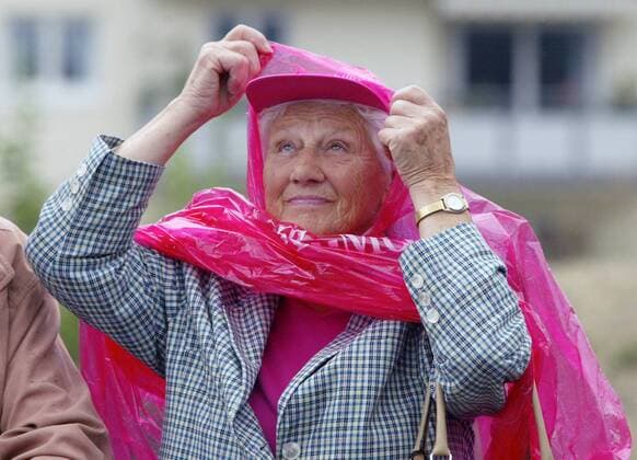 Ältere Dame schützt sich vor dem Regen mit einem Umhang von T Mobile und schaut, was das Wetter noch bringen wird Radsport Herren Deutschland Tour 2005, Deutschlandtour, ProTour, Straßenradsport, Straße, Rad, Rundfahrt Einzelbild 6. Etappe: Friedrichshafen - Singen