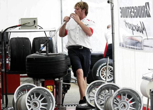 Ein Bridgestone Techniker zieht einen Reifen auf eine Felge Motorsport Grand Prix Herren Großer Preis von Italien 2005, Formel 1 Weltmeisterschaft, F1, F, GP, WM Einzelbild Monza