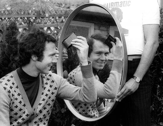 Anfänge des Marketing - Franz Beckenbauer (Bayern) posiert beim Shooting für die Haarschneidemaschine Hairmatic Fußball 1. BL Herren Saison 1976 1977, FC Bayern München, Vorstellung, Präsentation, Pressetermin Einzelbild Fotoshooting, Fototermin, Kleidung, Outfit, privat München