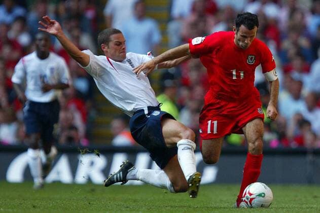 Ryan Giggs (Wales, re.) gegen Luke Young (England) -  Fußball Länderspiel Herren Weltmeisterschaftsqualifikation 2005, Nationalmannschaft, Nationalteam, Nationaltrikot, Länderspiel Gruppe Cardiff Dynamik, Kampf,