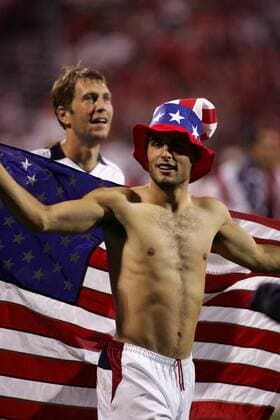 Landon Donovan (vorn) jubelt über den Sieg mit einer amerikanischen Nationalflagge und einem Hut in den Nationalfarben, dahinter Berhalter (beide USA) - (Icon9183587) Fußball Länderspiel Herren Weltmeisterschaftsqualifikation 2005, Länderspiel, Qualifikation, Nationalmannschaft, Nationalteam Gruppe stars and stripes Columbus Ohio Begeisterung, Freude, Komik, EDITORIAL USE ONLY