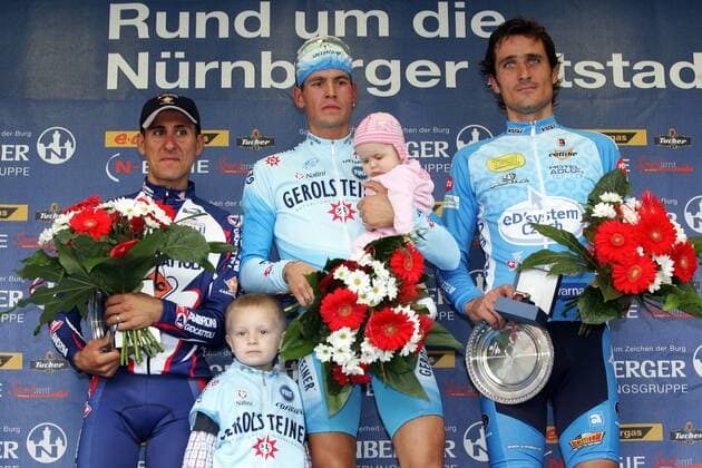 Siegerehrung Rund um Nürnberg 2005, v.li.: Raffaele Ferrara, Sieger Ronny Scholz (Deutschland Gerolsteiner, Mitte) erschöpft mit seinem Sohn auf dem Arm und Jan Valach (Slowakei Ed Syszem ZVVZ) Radsport Herren Rund um Nürnberg 2005, Straßenradsport, Straße, Rad Gruppe Nürnberg