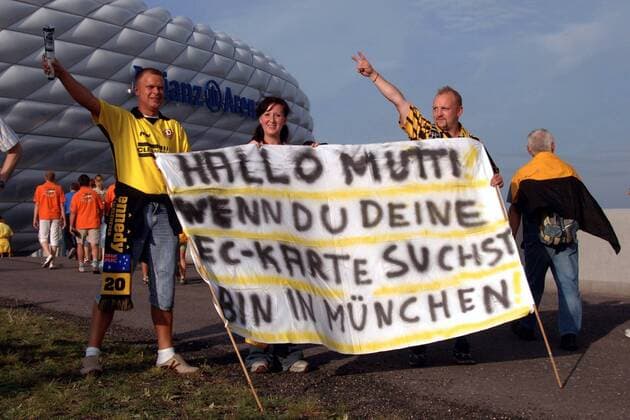 Dresdner Fans vor der Münchner Allianz Arena mit einem hoffentlich spaßig gemeinten Plakat - Hallo Mutti! Wenn Du Deine EC Karte suchst, bin in München! Fußball 2. BL Herren Saison 2005 2006, 1. FC Dynamo Dresden, o0 Auswärtsspiel, Gruppe Allianz Arena, AllianzArena München Komik,