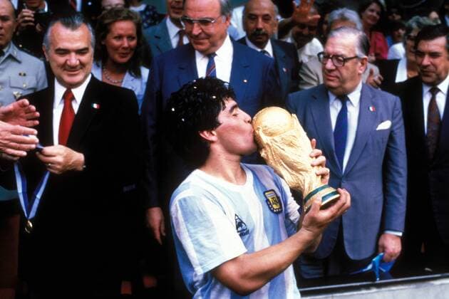 Diego Armando Maradona (Argentinien) küßt den Weltmeisterpokal, Staatspräsident Miguel da la Madrid Hurtado (li., Mexiko) wartet schon mit der Goldmedaille auf den Ausnahmekönner, daneben Bundeskanzler Dr. Helmut Kohl (CDU BR Deutschland) Fußball WM Herren Weltmeisterschaft 1986, Länderspiel, Nationalmannschaft, Nationalteam, Finale, Endspiel, Vdia Gruppe Siegerehrung, Podium, Podest Mexico City, Mexiko Stadt o0 Aufmacher Glück Freude, Begeisterung,