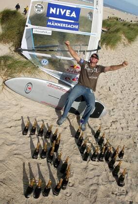 Björn Dunkerbeck ist 34maliger Weltmeister und fühlt sich wie ein junger Gott - Um seine einmalige Bilanz zu visualisieren, hat er die Zahl 34 mal aus ebenso vielen Sektflaschen im Sand gebaut und Männersache ist der Surfsport laut Sponsor Nivea sowieso Surfen Herren PWA Tour 2005, Nivea Worldcup, Weltcup, Welt Cup, World, WC, Surfing, Windsurfing, Windsurfen Einzelbild Sponsor, Sponsoring, Werbepartner, Werbung Westerland Sylt Schriftzug, Kosmetik Freude,