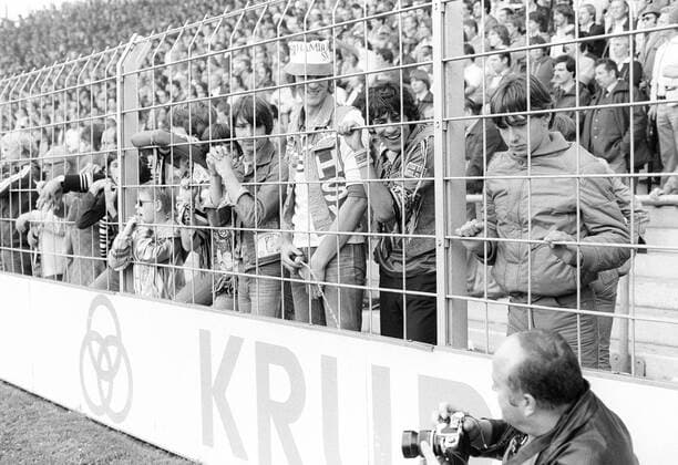 Ein ungehöriger Fan des HSV uriniert durch den Zaun in Richtung eines Fotografen Fußball 1. BL Herren Saison 1981 1982, Hamburger SV, Hamburg, Aufmacher, Saisonhighlight Gruppe o0 Zeitgeist 80er 80 er Jahre Bochum, Arbeitsbedingungen, Härte, brutal, Komik