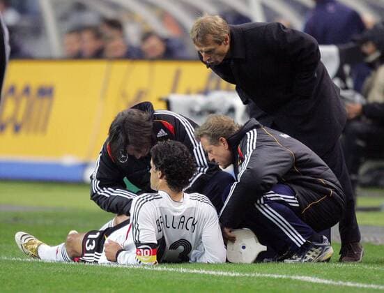 Mannschaftsarzt Dr. Hans Wilhelm Müller Wohlfahrt (li.) und Physiotherapeut Klaus Eder (re.) behandeln Michael Ballack, hi. Bundestrainer Jürgen Klinsmann (alle Deutschland) Fußball Länderspiel Herren Länderspiel 2005, Nationalmannschaft, Nationalteam, Test, Testspiel, Freundschaftsspiel, Deutschland Gruppe Paris