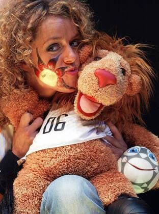 WM Maskottchen Goleo VI und sein Freund Pille, der sprechende Ball, in den Armen eines Models, das anläßlich der Trikotpräsentation eine glitzernde Gesichtsbemalung in den deutschen Landesfarben trägt Fußball WM Herren Trikotpräsentation 2005, Trikotvorstellung, Nationalmannschaft, Nationalteam, Pressetermin, Vdig Einzelbild Vorschau Weltmeisterschaft 2006 Köln