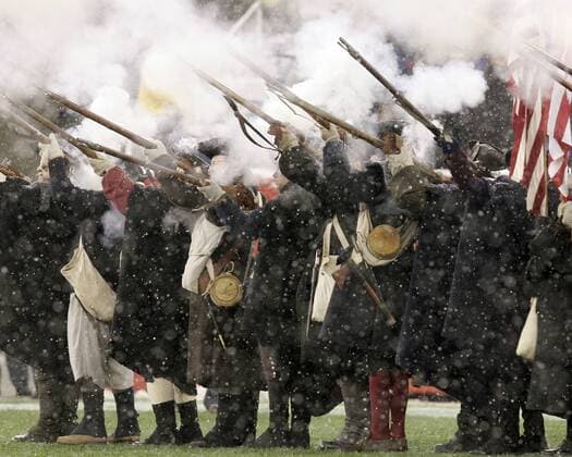 Soldaten in altertümlicher Kluft schießen zum Andenken an die Unabhängigkeit in die Luft - (Icon4611204) American Football Herren NFL 2005 2006, New England Patriots, Erinnerung, historisch, Schnee, Schneefall, Gruppe patriotisch, Revolution, unabhängig, Geschichte Foxboro EDITORIAL USE ONLY