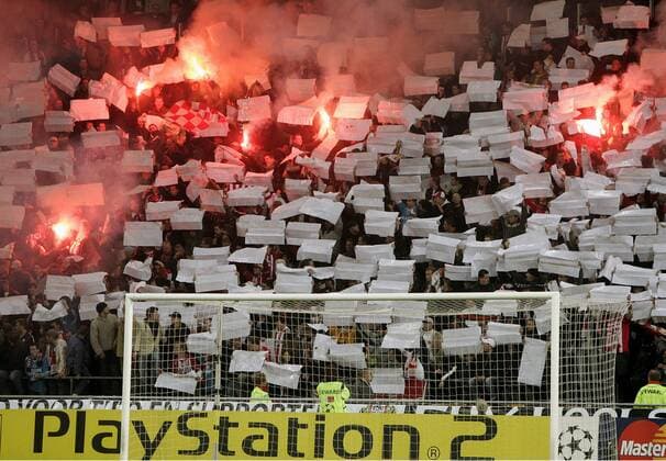 Fanchoreographie der Fans vom PSV Eindhoven mit Bengalfeuer und weißen Plakaten über einer Werbebande von Sponsor Sony PlayStation 2 -  Fußball EC 1 Herren Champions League 2005 2006, PSV Eindhoven, Wirtschaft, Bandenwerbung, Bande, Unterhaltungselektronik Totale Industrie, Elektronik, Schriftzug Eindhoven , Werbung Begeisterung, Freude,
