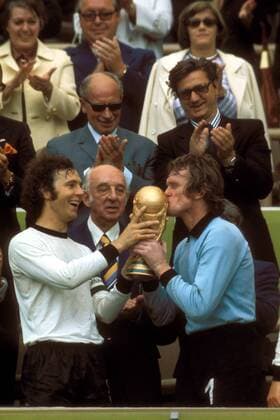 WM Siegerehrung: Franz Beckenbauer (li.) hält Torwart Sepp Maier den Pokal für den Siegerkuß, und das vor den Augen von DFB Präsident Hermann Gösmann (alle BR Deutschland) Fußball WM Herren Weltmeisterschaft 1974, Länderspiel, Nationalmannschaft, Nationalteam, Nationaltrikot, Vdia Gruppe Finale, Endspiel München Freude, Begeisterung,