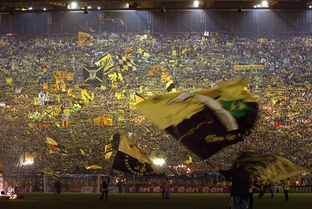 Dortmunder Fans sorgen auf der Südtribüne des Westfalenstadions unterstützt von Fahnenschwenkern für Stimmung Fußball 1. BL Herren Saison 2004 2005, Borussia Dortmund, BVB, Vdig Totale Dortmund Masse Freude, Begeisterung,
