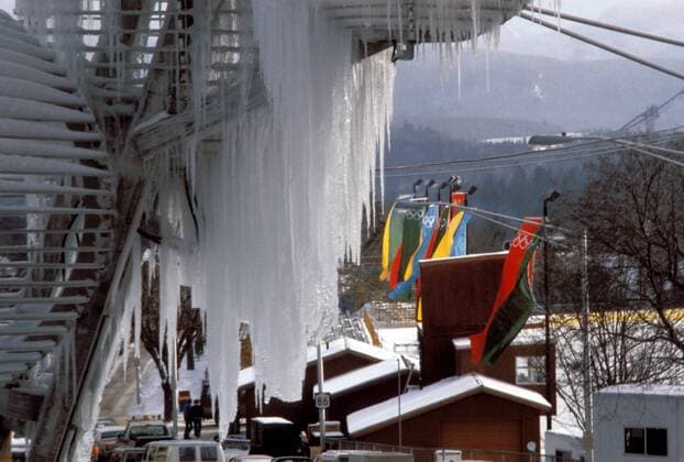 Eiszapfen an einer Wendeltreppe im Olympiaort Lake Placid, die Fahnen wehen bunt am Straßenrand Nordischer Skilauf OS Winter Herren Olympische Spiele 1980, Winterspiele, Ski Nordisch, Nordischer Skisport, Vdia Totale Lake Placid, Austragungsorte