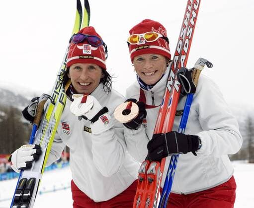 Silber und Bronze - Marit Björgen (li.) und Hilde Gjermundshaug Pedersen (beide Norwegen) zeigen ihre Medaillen -  (oly2006021611) Nordischer Skilauf OS Winter Damen Olympische Spiele Turin 2006, Winterspiele, Skisport, Ski Nordisch, Langlauf, klassisch Gruppe Pragelato Freude,