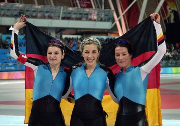 Deutschland ist Olympiasieger 2006 in der Mannschaftsverfolgung, v.li. jubeln Daniela Anschütz Thoms, Anni Friesinger und Claudia Pechstein mit der Nationalflagge -  Eisschnellauf OS Winter Damen Olympische Spiele Turin 2006, Winterspiele, Mannschaftswettbewerb, Teamwettbewerb, Teamverfolgung Gruppe Turin Freude,