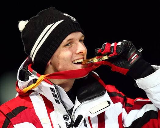 Olympiasieger Thomas Morgenstern (Österreich) prüft die Goldmedaille Skispringen Herren Olympische Spiele Turin 2006, Winterspiele, Ski Nordisch, Nordischer Skisport, Großschanze, Einzelbild Pragelato Freude,