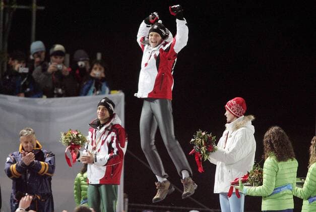 Olympiasieger Thomas Morgenstern (Mitte) mit einem Freudensprung während der Siegerehrung, Andreas Kofler (li., beide Österreich Platz 2) und Lars Bystöl (Norwegen Platz 3) komplettieren das Bild -  Skispringen OS Winter Herren Olympische Spiele Turin 2006, Winterspiele, Ski Nordisch, Nordischer Skisport, Großschanze, Vdig Gruppe Pragelato Glück, Überlegenheit, Freude, Begeisterung,