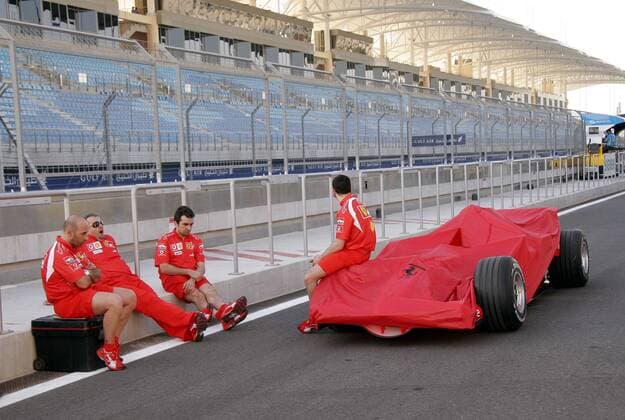 Techniker mit dem abgedeckten Boliden Michael Schumachers (Deutschland Ferrari) Motorsport Grand Prix Herren Großer Preis von Bahrain 2006, Formel 1 Weltmeisterschaft, F1, F, GP, WM, Gruppe Sakhir Manama Langeweile,
