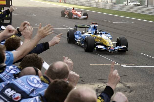 Sieger Fernando Alonso (Spanien Renault) wird bei der Zieldurchfahrt von seinem Team umjubelt, dahinter der Zweitplatzierte Michael Schumacher (Deutschland Ferrari) in seinem Boliden Motorsport Grand Prix Herren Großer Preis von Bahrain 2006, Formel 1 Weltmeisterschaft, F1, F, GP, WM Totale Bahrain International Circuit Manama, Sakhir Begeisterung, Freude,