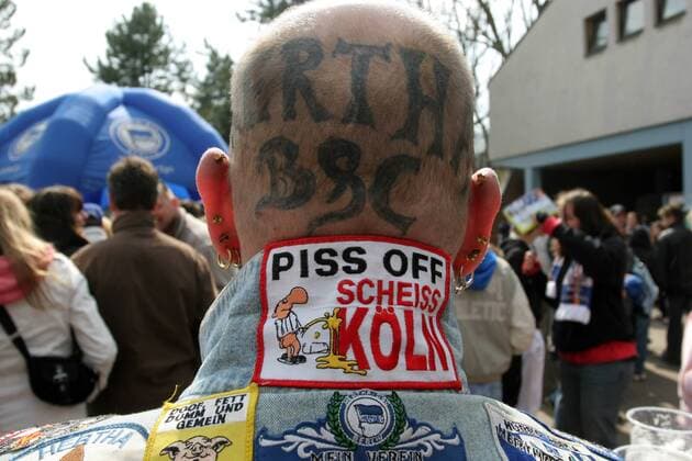 Piss Off Scheiss Köln - ein am Kopf tätowierter Hertha Fan äußert auf vulgäre Art und Weise seinen Unmut gegenüber dem 1. FC Köln Fußball 1. BL Herren Saison 2005 2006, Hertha BSC Berlin, Beschimpfung, beleidigen, beschimpfen, provozieren, provokant Einzelbild Feindschaft, Fanfeindschaft, Beleidigung Tätowierung, tätowiert, Hinterkopf