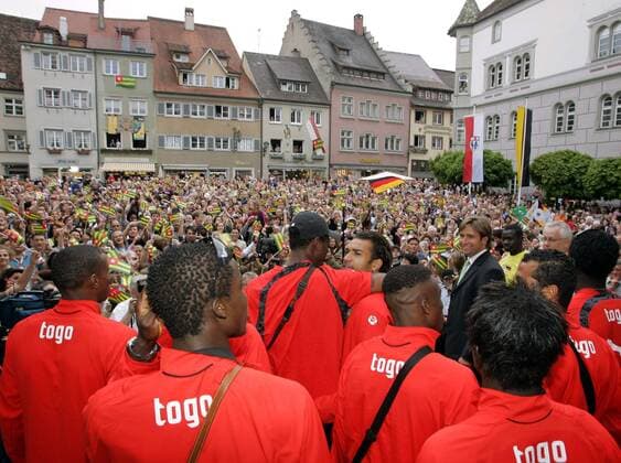 Willkommensparty für die Nationalmannschaft aus Togo auf dem Marktplatz in Wangen i. A. - Oberbürgermeister Michael Lang (5.v.re.) begrüßt mit den Einwohnern das togolesische Nationalteam, das während der WM 2006 hier gastieren wird Fußball WM Herren Vorschau Weltmeisterschaft 2006, Nationalmannschaft, Nationalteam, Ankunft, Empfang, Party, Vdig Totale Wangen i. A., Stadt, Stadtbild