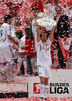 Mehmet Scholl präsentiert stolz vor dem Siegerpodium die Meisterschale, Trainer Felix Magath (re.) und Lucio (alle Bayern) schauen zu Fußball 1. BL Herren Saison 2005 2006, FC Bayern München, Deutscher Meister, Deutsche Meisterschaft, Meisterfeier, Vdig Einzelbild München Freude,