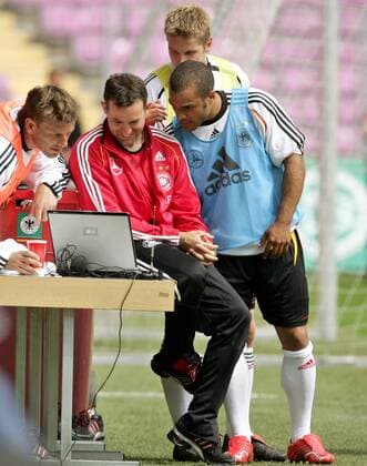 Trainingsberater Craig Friedman (USA Athlete Performance, 2.v.li.) zeigt Bernd Schneider (li.) David Odonkor (re.) und Thomas Hitzlsperger (alle Deutschland) die Leistungsergebnisse auf seinem Laptop Fußball WM Herren Nationalmannschaft 2006, Nationalteam, Training, Trainingslager, Vorbereitung Gruppe Leibchen, Trainingsleibchen, AP, Trainerstab, Genf