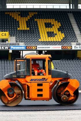 Der Boden des Stade de Suisse, Heimspielstätte der Young Boys Bern, wird vorbereitend für das Verlegen von Kunstrasen asphaltiert und planiert Fußball Herren Super League 2005 2006, Nationalliga A, NLA, 1. Schweizer Liga, BSC, Vereinsname, Tribüne, YB, Vdig Totale Planieren, Wankdorf, Wankdorfstadion Bern, Baumaschine, Walze, Weibel, Baugewerbe, 