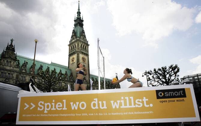 Spiel wo du willst - Zwei Beachvolleyballerinnen haben sich in dem Falle für das Hamburger Rathaus während der German Masters 2006 entschieden Beachvolleyball Damen German Masters 2006, Nestea European Championship, Beach, bewölkt Smart, Sponsor, Sponsoring, Totale Beachvolleyballerin, Beachvolleyballspielerin Hamburg, Aufschrift, Himmel, Wolken Werbung,