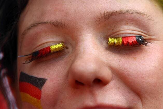 Weiblicher deutscher Fan hat sich die Wangen und Wimpern in den Nationalfarben Schwarz rot und Gold gestaltet Fußball WM Herren WM 2006, Länderspiel, Nationalteam, Gruppe A, Deutschland Porträt München