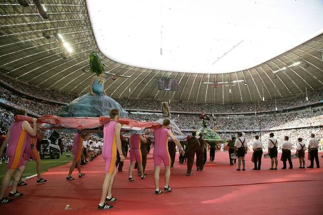 Eröffnungsfeier zur WM 2006: Statisten mit riesigen Röcken werden von Trägern ins FIFA WM Stadion München getragen Fußball WM Herren WM 2006, Länderspiel, Eröffnungsspiel, Eröffnungsfeier, Feier, Party, Eröffnung, Zeremonie Totale o0 World Cup Stadium München