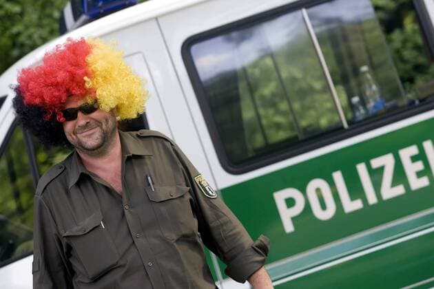 Fußballfieber kennt keine Grenzen: Ein gut gelaunter Berliner Polizist mit Afro Perücke in den deutschen Nationalfarben Fußball WM Herren WM 2006, FIFA Fanmeile, Fanfest, Fan Fest, Party, Deutschland, deutsche, Nationalteam Einzelbild Berlin Freude, Komik,