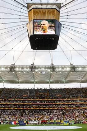 Auf dem Videowürfel erscheint das Konterfei von Zinedine Zidane, während seine Mannschaft aus Frankreich und der Gegner aus Brasilien zu den Nationalhymnen bereitstehen - Fußball WM Herren WM 2006, Länderspiel, Nationalteam, Viertelfinale, Nationaltrikot, Brasilien - Frankreich Totale World Cup Stadium, Worldcup Frankfurt M. Seildachkonstruktion, Seilzug Fußball WM Herren WM 2006, Länderspiel, Nationalteam, Viertelfinale, Nationaltrikot, Brasilien - Frankreich Totale World Cup Stadium, Worldcup Frankfurt M. Seildachkonstruktion, Seilzug