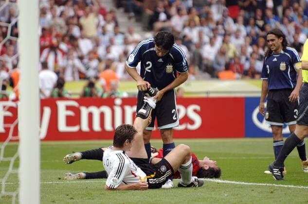 Roberto Ayala (Mitte, Argentinien) hilft Miroslav Klose (Deutschland) nach dem Zusammenprall mit Torwart Roberto Abbondanzieri (Argentinien) die Wade zu lockern, der Keeper liegt mit Schmerzen am Boden Fußball Herren WM 2006, Länderspiel, Nationalteam, Nationaltrikot, Deutschland - Argentinien 4:2 n.E., Vdig Gruppe Berlin Kameradschaft, Fußball Herren WM 2006, Länderspiel, Nationalteam, Nationaltrikot, Deutschland - Argentinien 4:2 n.E., Vdig Gruppe Berlin Kameradschaft,