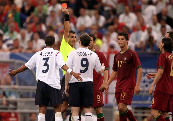 IMAGO Iconic Moments, Fußball FIFA Schiedsrichter Horacio Elizondo (Argentinien) zeigt Wayne Rooney (England) die rote Karte, beobachtet von Pauleta (2.v.re.) und Cristiano Ronaldo (beide Portugal, re.) sowie Aaron Lennon (England) Fußball WM Herren WM 2006, Länderspiel, Nationalteam, Viertelfinale, Nationaltrikot, England - Portugal 1:3 n.E. Gruppe Gelsenkirchen Fußball WM Herren WM 2006, Länderspiel, Nationalteam, Viertelfinale, Nationaltrikot, England - Portugal 1:3 n.E. Gruppe Gelsenkirchen